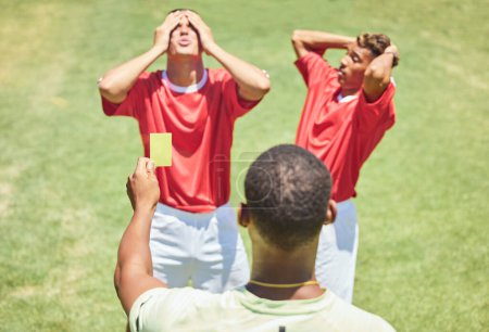 Photo for Sports, soccer and referee with yellow card standing on field with upset, angry and mad soccer players. Foul, mistake and athlete getting warning for rules violation in game or match on soccer field. - Royalty Free Image