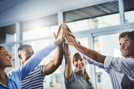 Photo for There is power in unity. Closeup shot of a group of businesspeople high fiving each other in an office - Royalty Free Image