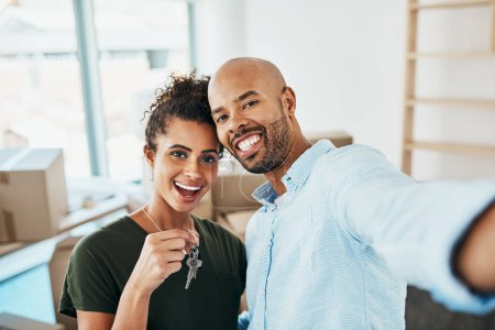 Photo for Guess who just unlocked a new goal. Portrait of a young couple taking a selfie while holding the keys to their new home - Royalty Free Image
