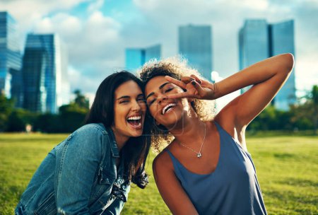 Téléchargez les photos : Amitié, rire et paix. Portrait recadré de deux bonnes copines heureuses dans un parc - en image libre de droit