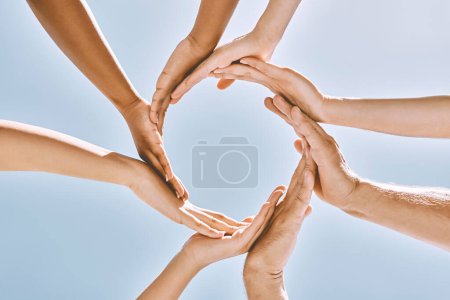 Hände, Menschen und vertrauensvolle Zusammenarbeit sorgen für Gemeinschaft, Unterstützung und Synergien auf blauem Himmel. Hoffnung, Hand und Gruppe mit Vielfalt, Hilfe und Solidarität, Umwelt und Teamarbeit blauer Hintergrund.