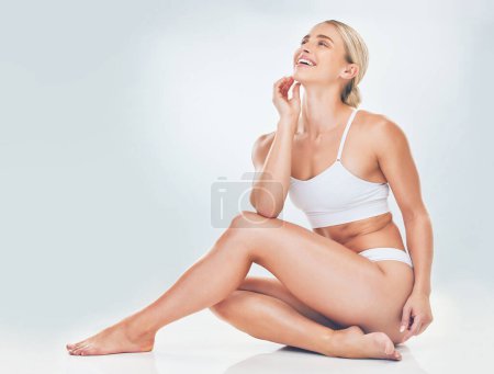 Natural, body positivity and woman in underwear in studio for self love, empowerment and wellness. Happy, smile and girl model embracing beauty of body isolated by a gray background with mockup space.