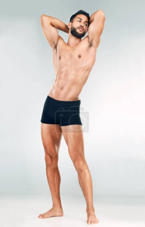 Muskel, Kraft und Körper eines Mannes für Fitness, Gesundheit und Tormotivation vor grauem Studiohintergrund. Denk-, Sport- und Bodybuildermodel mit sexy, jungen und gesunden Bauchmuskeln aus Sport.