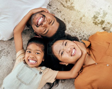 Photo for Love, floor and portrait of relax happy family having fun, bond and enjoy quality time together while lying on ground carpet. Happiness, big smile and Malaysia vacation for parents and child top view. - Royalty Free Image