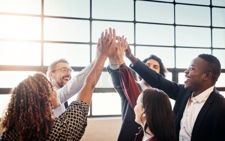 Photo for Teamwork makes the dream work. a diverse team of happy businesspeople high fiving each other in the office - Royalty Free Image
