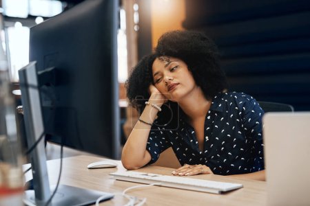 Foto de Voy a descansar los ojos un segundo. una joven diseñadora cansada que se queda dormida detrás de su computadora en la oficina durante el día - Imagen libre de derechos