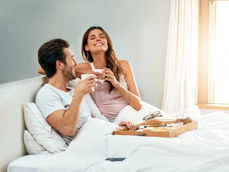 Podría despertarme así todos los días. una feliz pareja joven disfrutando del desayuno en la cama juntos en casa