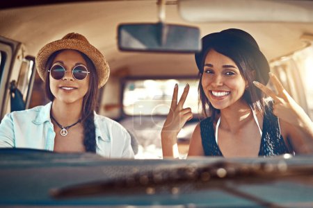 Photo for Ready for whatever the road brings. two happy friends showing a peace sign on a roadtrip - Royalty Free Image
