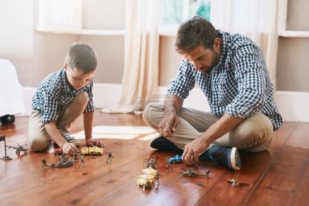 Photo for Help them to enjoy their childhood. a young boy and his father playing with cars on the floor - Royalty Free Image