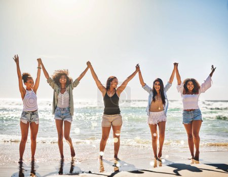 Legen Sie die guten Zeiten an. eine Gruppe fröhlicher Freunde, die sich am Strand an den Händen halten
