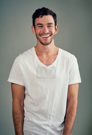 The laughing mood, the best of all. Studio shot of a casual young man posing against a grey background