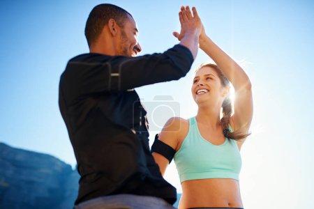 Photo for Keeping fit really does make you feel good. a sporty young couple high fiving each other outside - Royalty Free Image