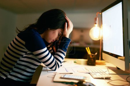 Foto de Estoy tan acabado este día. una joven mujer de negocios que parece estresada mientras trabaja hasta tarde en una oficina - Imagen libre de derechos