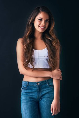 She just radiates with this cool and confident vibe. Studio portrait of an attractive young woman posing against a dark background
