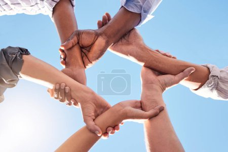Photo for Hands, community and link team together global community of cooperation on blue sky. Group diversity in volunteer partnership, social solidarity or collaboration friends of circle arms and teamwork. - Royalty Free Image