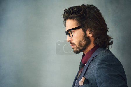 Hes a profile of style. Studio profile shot of a stylishly dressed handsome young man wearing glasses
