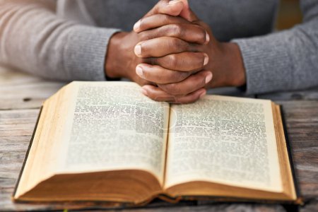 Téléchargez les photos : Méditer sur la parole de Dieu. Plan grand angle d'un homme méconnaissable lisant sa bible assis à l'extérieur - en image libre de droit