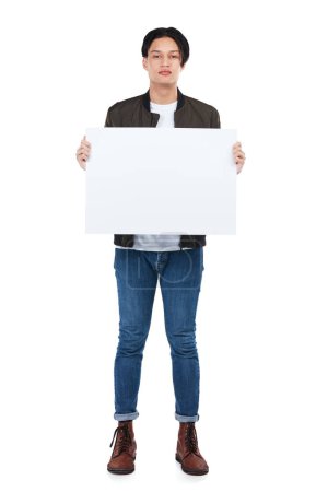 Photo for Advertise here. Full length portrait of a young man holding an empty sign against a white background - Royalty Free Image
