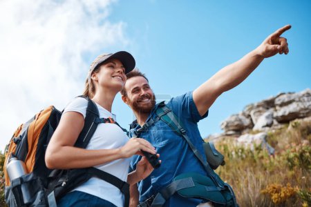 Couple, pointing and bonding on hiking mountains, nature earth environment or countryside hills in Canada. Smile, happy and hiker man and woman backpacking or sightseeing camping land with binoculars.