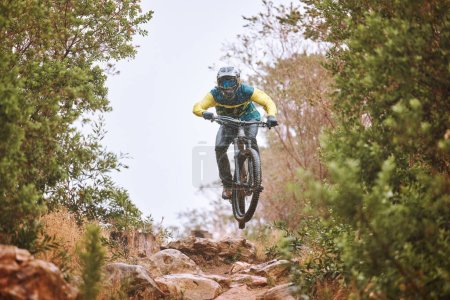 Photo for Mountain bike, sports and fitness with a man adrenaline junkie riding in the woods or forest in nature. Sky, training and exercise with a male athlete on a bike for trail riding or adventure. - Royalty Free Image