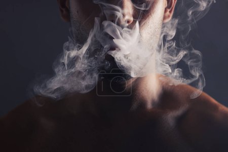 Photo for Smoke, cloud and face of man with pollution for marijuana smoker health campaign with zoom. Cannabis, weed and cbd addiction model for smoking habit lifestyle advertising in black studio - Royalty Free Image