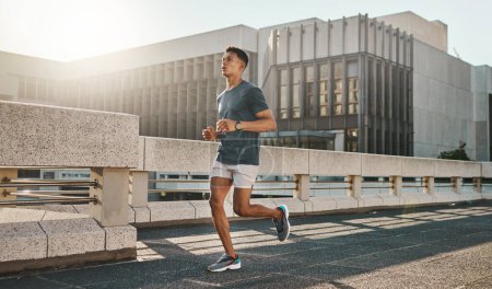 Fitness, health and city man running on street with motivation, healthy mindset and summer morning energy for training. Urban workout, cardio exercise and runner on bridge, focus on sports lifestyle