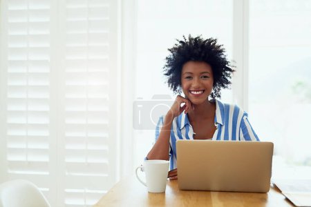 Téléchargez les photos : Travailler à la maison me convient le mieux. Portrait d'une jeune femme travaillant sur son ordinateur portable à la maison - en image libre de droit