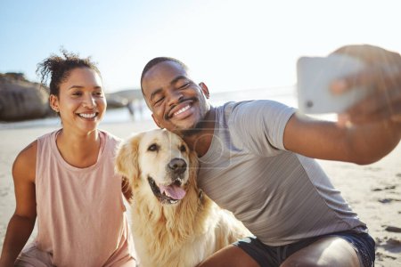 Photo for Couple, phone selfie and dog on beach for social media post, video call or memory vlog by ocean, sea or water. Smile, happy or bonding black woman, man and golden retriever in mobile photography tech. - Royalty Free Image