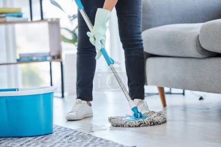 Mop, flooring and woman cleaning living room house, home and apartment. Cleaner, maid and housekeeping service on wet ground, care and safety of virus, bacteria and dust for household disinfection.