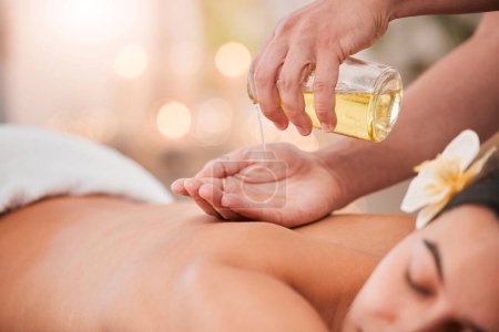 Hand, oil and massage on woman at a spa for wellness, relax and stress relief with back massage and masseuse. Luxury, back and girl hands of therapist with product for body, skin and muscle therapy.