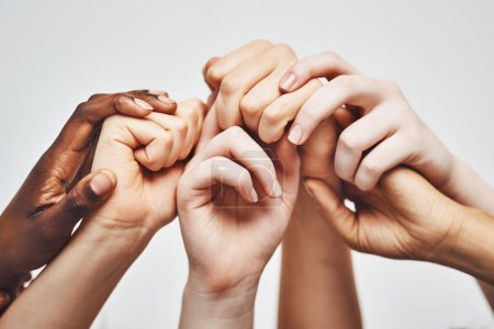 Foto de Aférrate a lo que te haga más fuerte. un grupo de manos agarrándose unas a otras sobre un fondo blanco - Imagen libre de derechos