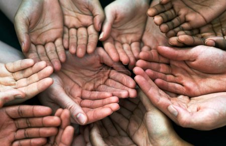 Photo for Help us out. a group of hands held cupped out together - Royalty Free Image