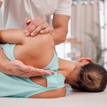 Doctor, chiropractor and woman with back pain for physiotherapy from a physiotherapist helping with spine alignment. Rehabilitation and chiropractic worker healing a healthy girls spinal posture.