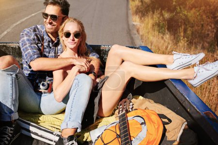 Photo for Kicking off an entire weekend on the road. a young couple relaxing on the back of a pickup truck while on a road trip - Royalty Free Image