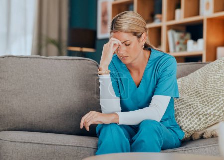 Worry, stress and burnout woman nurse sitting on sofa of modern apartment home sad with depression from work. Hand on head, anxiety and tired nursing in mental health distress on couch of living room.