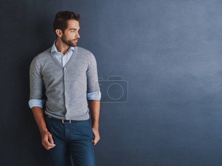 The modern businessman. a handsome young businessman posing against a dark background