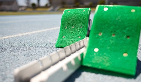 Photo for Sports closeup, starting blocks and running track, field or pitch for training, exercise or sprint in arena. Start, ready and race with equipment for sport, fitness or workout on ground at stadium. - Royalty Free Image