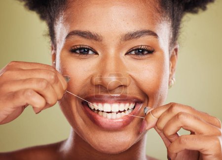 Floss, dientes y retrato de una mujer negra con promoción dental, odontológica y de bienestar bucal en estudio verde. Modelo africano joven, producto de limpieza dental y hilo dental para publicidad sanitaria.