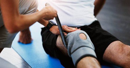 Rehabilitation, woman therapist or knee brace in physiotherapy with senior man patient, knee pain or consulting expert. Physiotherapist, physical therapy and healthcare worker help, support or advice.