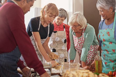 Photo for Showing them how to cut their kitchen time in half. a group of seniors attending a cooking class - Royalty Free Image