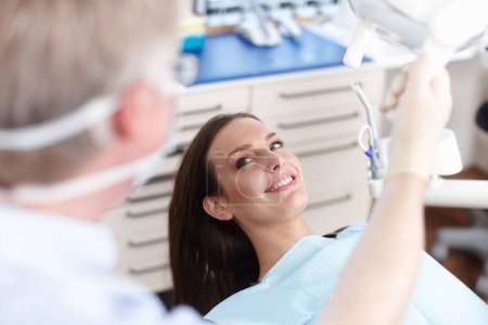 Paciente sonriente con dentista. Vista de ángulo alto del paciente sonriendo con el dentista en la clínica