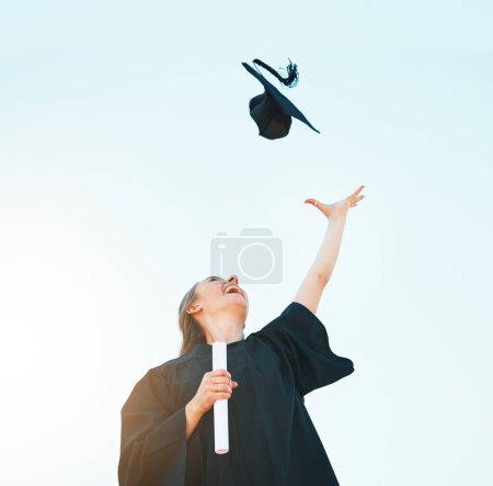 Photo for Woman celebrate graduation hat in blue sky for success, achievement and goals of university certificate, college diploma and education motivation. Below of excited graduate and graduation cap in air. - Royalty Free Image