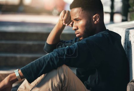 Depressive, wütende und schwarze Männer sind aufgebracht, müde und unglücklich draußen in der Stadt, starren und frustriert. Psychische Gesundheit: Afroamerikaner und junger Mann mit Problemen, Misserfolg und Depressionen