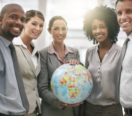 Photo for Ready to take on the world. Cropped portrait of a businesswoman holding a globe while standing with her colleagues - Royalty Free Image