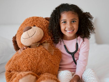 Estetoscopio, osito de peluche y niña con un niño su peluche con una sonrisa en su casa. Retrato de una niña feliz sosteniendo un juguete esponjoso, aprendiendo a ser médico o pediatra en atención médica.
