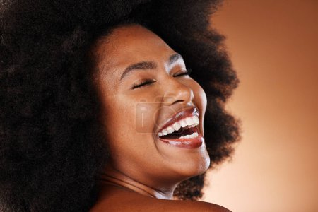 Black woman, afro hair and laughing face expression on studio background in self love, empowerment or acceptance. Zoom, smile or happy beauty model with natural hair, white teeth and makeup cosmetics.