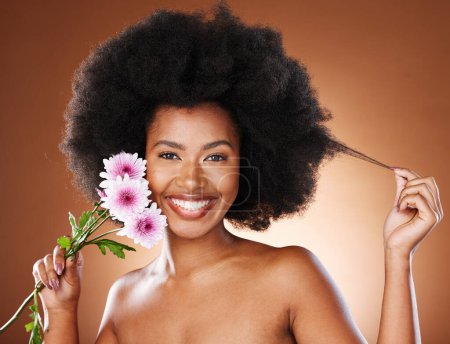 Photo for Black woman, flowers and natural beauty, afro hair and glowing skincare, organic makeup or eco dermatology on studio background. Portrait happy african model, curly hair and pink daisy blossom plants. - Royalty Free Image