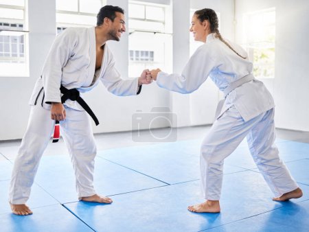 Photo for Fist bump, support and couple in karate, training and teaching in partnership for motivation in self defense. Goal, fight and man and woman with unity in taekwondo for exercise and fitness at a club. - Royalty Free Image