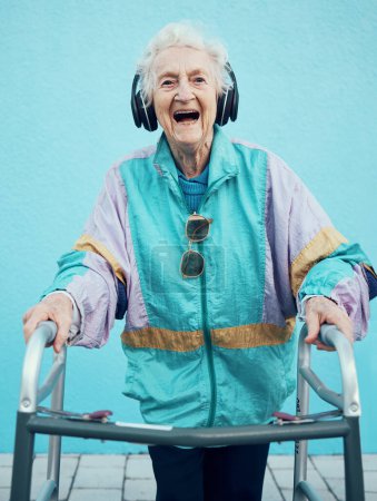Mode, Kopfhörer und Porträt einer Seniorin mit Gehgestell und Vintage-Kleidung der 1980er Jahre. Rentner, ältere und glückliche Frauen in Retro-, Cool- oder Designerjacke, die Musik, Radio oder Podcast streamen.