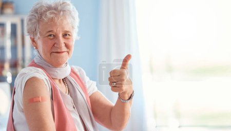 Senior woman, vaccine and covid with thumbs up in portrait, hospital and smile with plaster. Happy elderly lady, vaccination and yes hand for safety, healthcare or medical protection against covid 19.